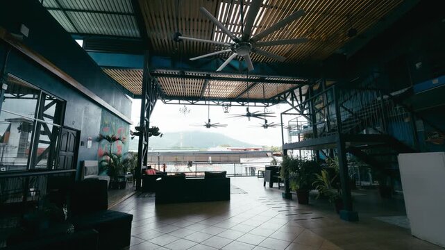 Interior of a vibrant hostel lounge in Costa Rica, featuring a modern design with an open air terrace overlooking lush green mountains