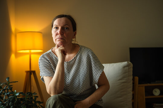 Mature woman looking turning face to the camera. Reflection, uncertainty and thoughtful decision-making concept.
