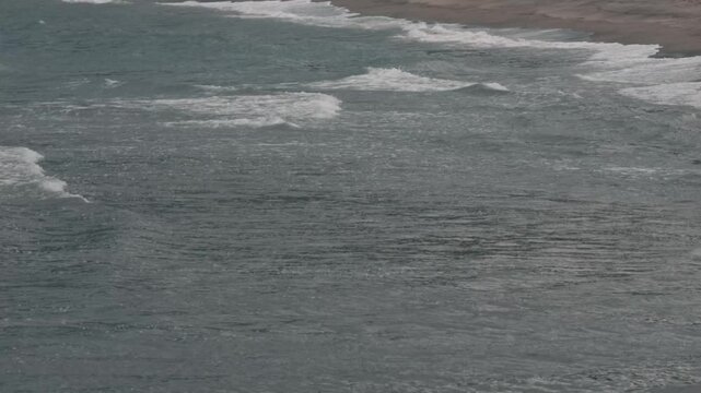Gray waves lapping onto the shore