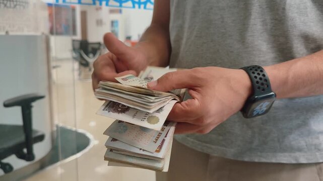 Title:

Counting egyptian pound banknotes, close-up of hands holding egyptian currency