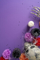 Fototapeta premium Dia de los Muertos altar with skulls, candles, marigolds and smoky purple vertical background
