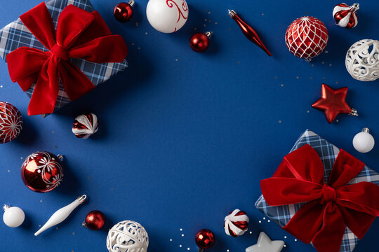 Christmas presents and red ornaments on blue background with Merry Christmas and Happy New Year message