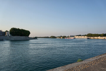Rhone river winding by arles city and cruise boats during golden hour © enriscapes