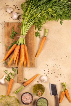 Fresh carrots and spices lay on chopping board