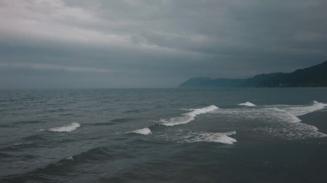 Gray waves lapping onto the shore