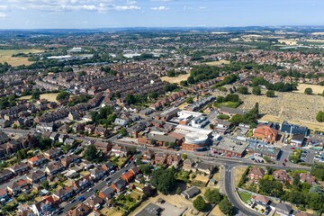Fototapeta premium Aerial photo overlooking Mexborough in South Yorkshire England showing the town centre residential housing cemetery public buildings and surrounding countryside beneath a bright blue summer sky
