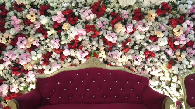 Luxury Wedding Stage and Floral Wall Background with Maroon Velvet Seating &ndash; Reception Decor Concept