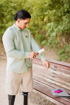 Latino man with prosthetic legs grooming shirt