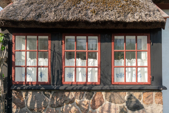 Traditionelles d&auml;nisches Bauernhaus mit Reetdach unter blauem Himme