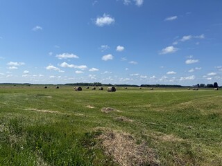 Rural Scene with Hay Bails and Blue Sky with Puffy Clouds and Green Landscape © Jason Lee