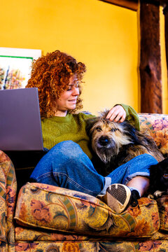 Woman working from home petting dog, balancing comfort, remote work, and pets