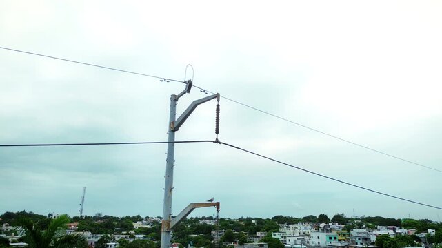 Drone aerial view of electrical transmission pole featuring cable infrastructure and attachment hardware with orbital camera movement