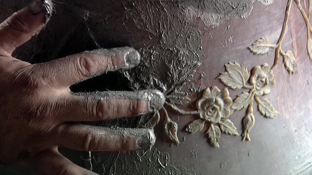 Artisan Hand Applying Clay Mixture over Decorative Rose Reliefs on Bell Mold - 4K