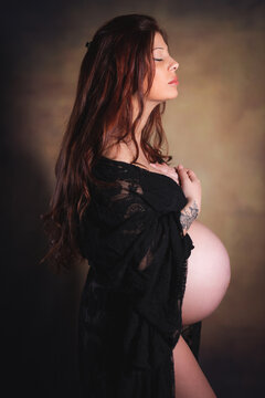 ritratto in studio durante sessione fotografica di  maternity di giovane donna in cinta al nono mese