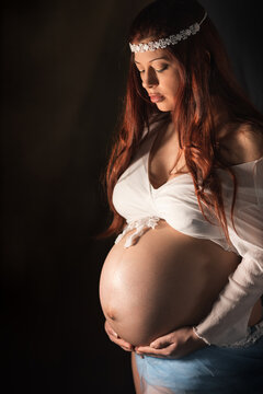 ritratto in studio durante sessione fotografica di maternity di giovane donna in cinta al nono mese