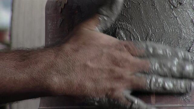 Close Up of Artisan Applying Clay Paste over Wax Saint Medallion on Bell Mold - 4K