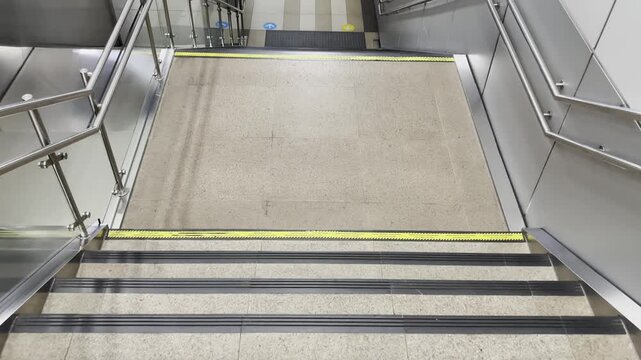 First person view walking down a staircase toward an MRT station, representing urban mobility, commuting, and public transportation.