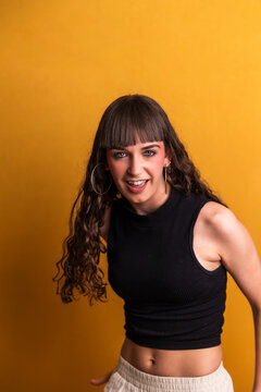 Young woman dancing with energy on yellow background
