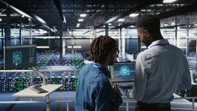 A data center engineering team maintains rigs handling AI processing tasks; server hub colleagues manage storage arrays supporting deep learning training workflows and infrastructure stability.