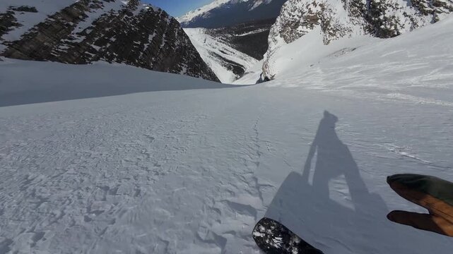 POV Snowboarding Down Open Backcountry Powder Face In Canadian Rocky Mountains During Winter