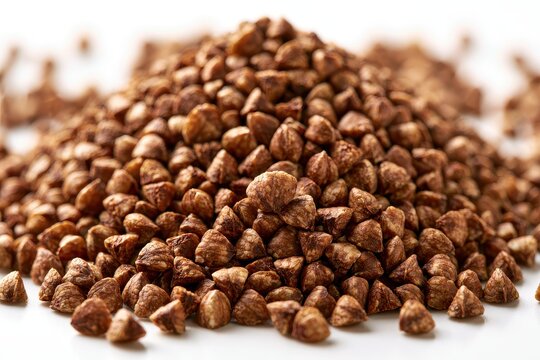 A pile of raw buckwheat groats isolated on white background
