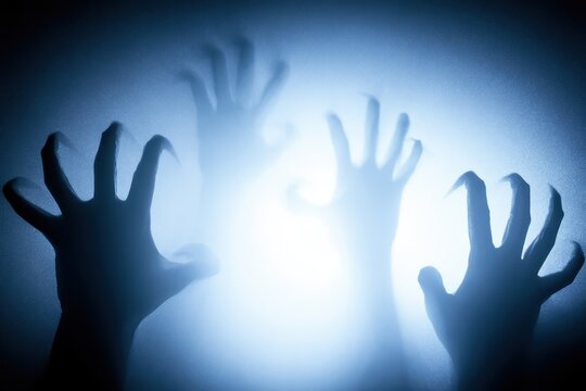 Scary hands pressing against frosted glass, silhouettes of hands behind a glass pane in the dark, horror and thriller concept, halloween background
