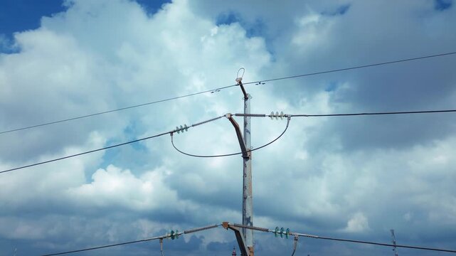 Drone aerial view of electrical transmission pole featuring cable infrastructure and attachment hardware with orbital camera movement