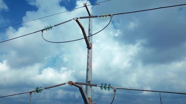 Drone aerial view of electrical transmission pole featuring cable infrastructure and attachment hardware with orbital camera movement