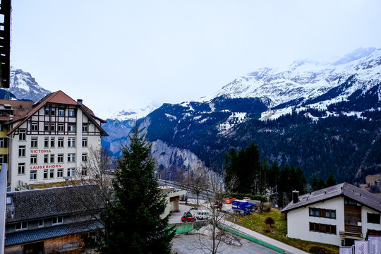 Wengen, Switzerland - 11.03.2026. A stunning landscape photograph featuring the historic facade of the Arena Hotel Victoria Lauberhorn in the car-free mountain village of Wengen, Switzerland. Set agai