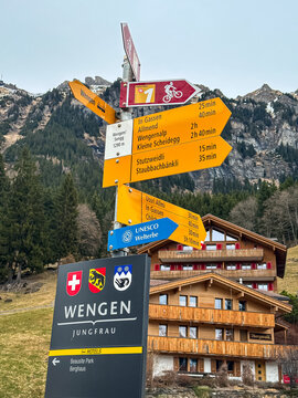 Wengen, Switzerland - 11.03.2026. A detailed close-up shot of the iconic yellow pedestrian trail markers and destination signposts in the alpine village of Wengen, situated at an altitude of 1290 mete