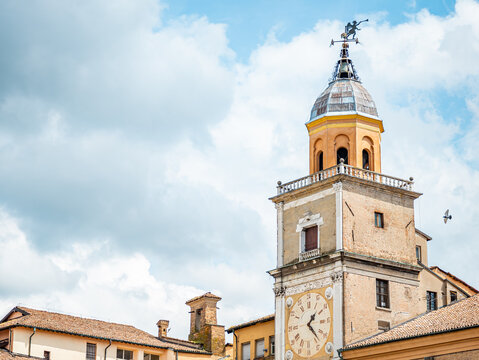 Torre dell'Orologio. A historic clock tower and architectural landmark of the Palazzo Comunale in Modena. Italy. Rising against a light cloudy sky