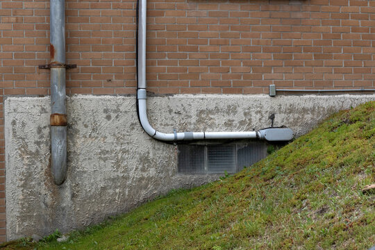 Metal and plastic piping on a brick wall