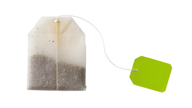 Isolated single tea bag with string and bright green blank tag for hot beverage.