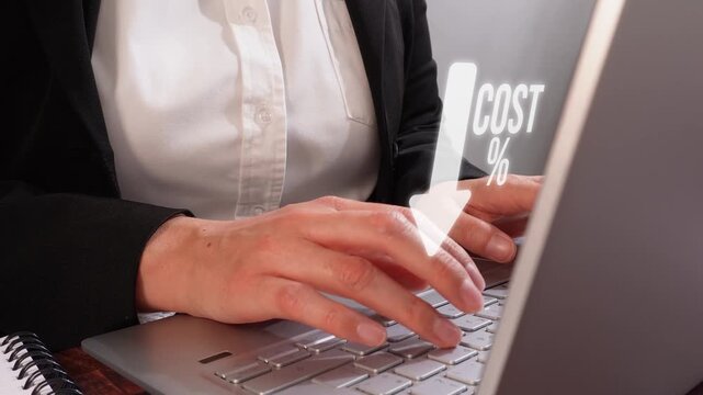 Close-up of hands typing on laptop. Digital arrow points downward with 'COST %' text. Shows focus on budgeting or financial reduction. Ideal for business, finance