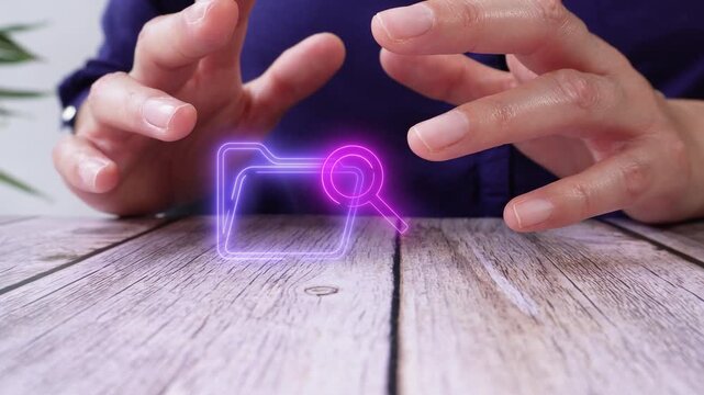 Person gestures over glowing folder with magnifying glass. Hands hover above wooden surface. Neon icon suggests digital search or file review. Ideal for tech, data, or digital organization themes