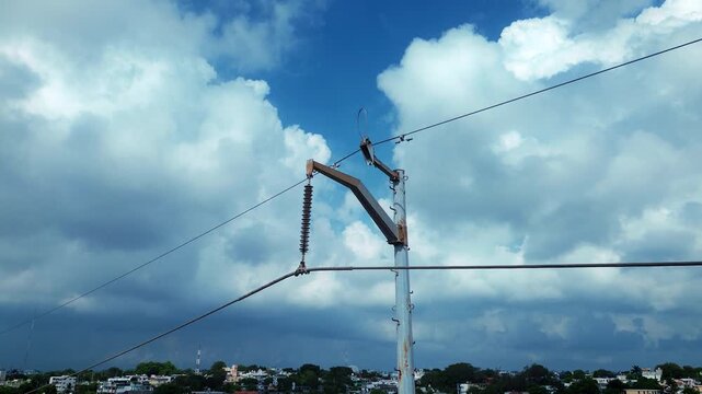 Drone aerial view of electrical transmission pole featuring cable infrastructure and attachment hardware with orbital camera movement