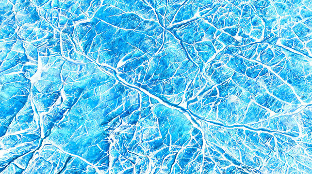 cracked frozen ice surface texture with white fracture line network and icy frost pattern.