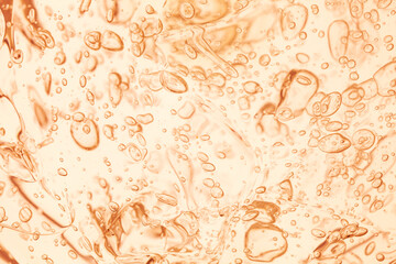 Abstract macro background of orange cosmetic gel texture with clear oxygen bubbles. Moisturizing skincare product orretinol serum close-up, liquid drops pattern. © tatyanarow
