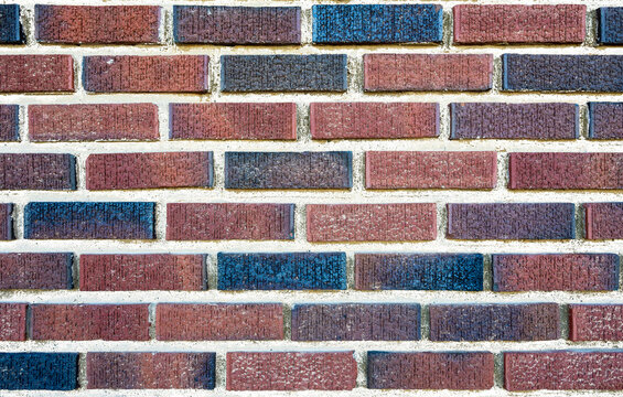 Background of brick wall with multi-colored bricks and transparent grout cement
