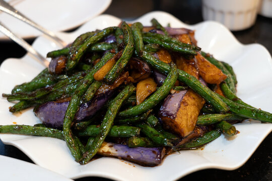 Stir-fried Chinese long beans and eggplant tossed in a savory garlic soy sauce. This vegetable dish features vibrant colors, tender-crisp texture, and rich umami flavors.