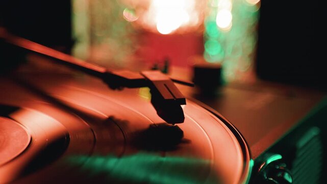 Vinyl record spinning on a vintage turntable with warm lighting. Retro audio equipment playing music in a dark room. Concept of analog sound and music nostalgia.