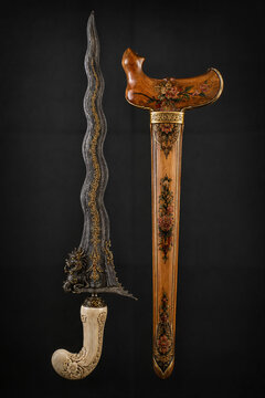 Traditional Indonesian keris dagger with wavy blade and carved wooden handle