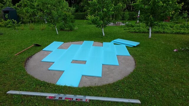 Preparing a backyard pool foundation with foam panels for summer installation