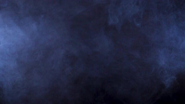 Abstract smoke clouds dispersing fill a black studio backdrop, turning cloud motion and soft fog into abstract texture for dark edits and transition sequences.