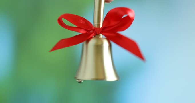 Woman beautiful ringing golden handbell outdoors, closeup