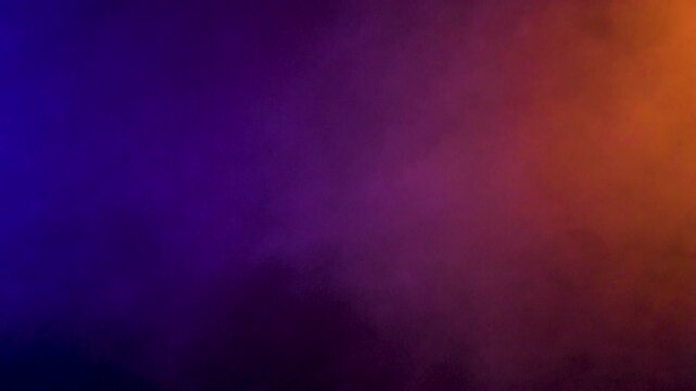 Colorful smoke clouds dispersing fill a black studio backdrop, turning cloud motion and soft fog into abstract texture for dark edits and transition sequences.