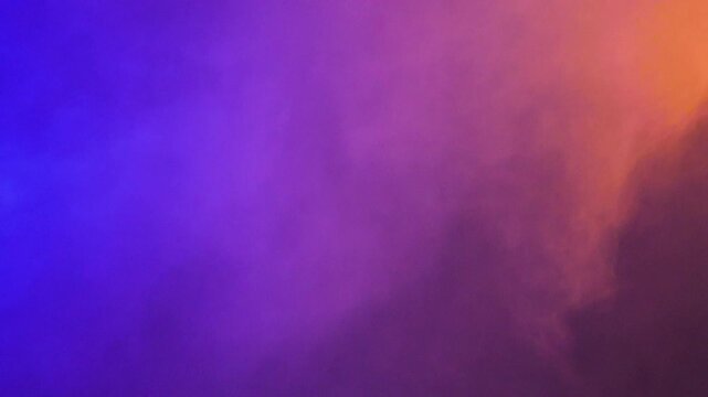 Dynamic colorful smoke clouds move over a black studio background, creating a vivid vapor texture for overlays, transitions and visual effects.