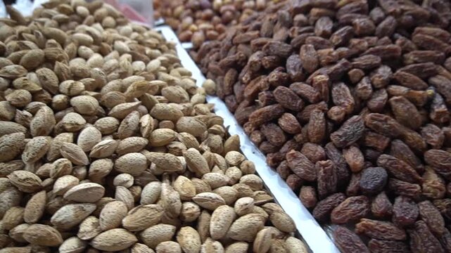 A huge pile of sweet dried brown dates stacked tightly together for sale at a bustling traditional bazaar