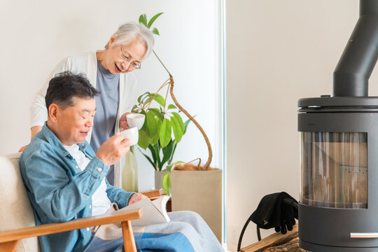 リビングでコーヒーを飲みながらくつろぐシニア夫婦