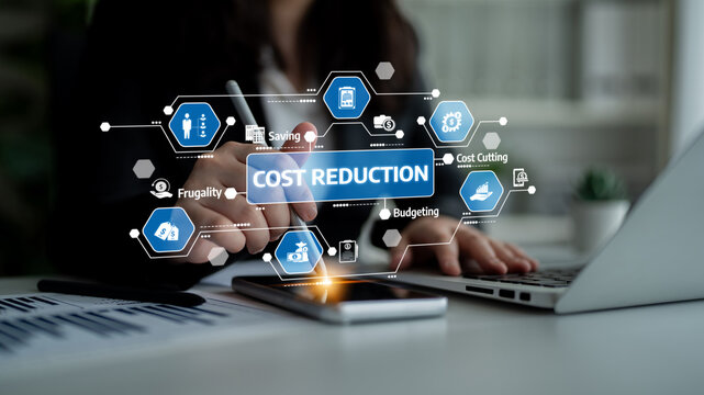 A business professional engages in cost reduction strategies using digital tools and visual data in a modern office environment, emphasizing efficiency and productivity. Tessel